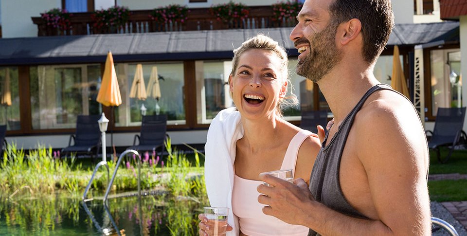 Foto: Paar am Biobadeteich beim Adults only Wellnesshotel in Tirol Österreich in Leutasch