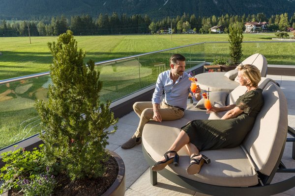Foto: Paar genießt die Dachterrasse vom Spa Hotel Leutasch für Erwachsene in Tirol, Österreich beim Urlaub mit Hund.